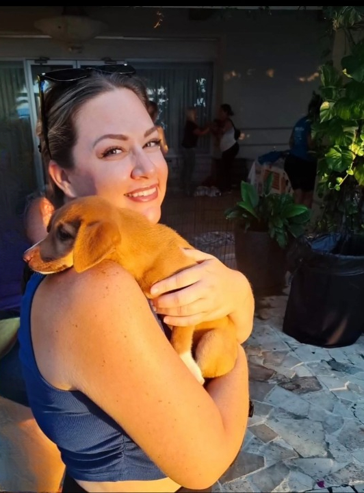 Kelly Wertz cradling an orange puppy