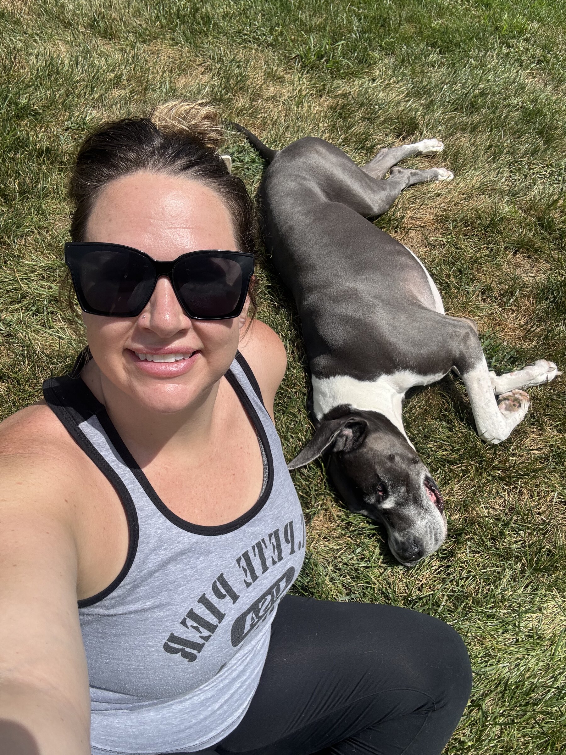 Kelly Wertz with a pit bull puppy on the lawn